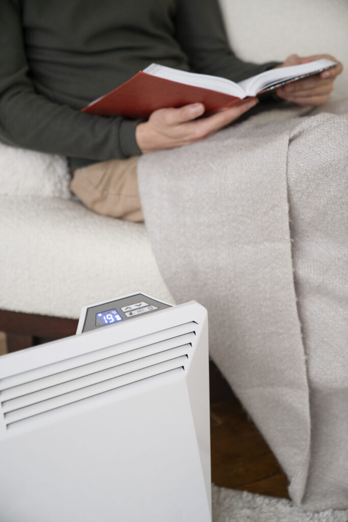 Man breathing fresh air next to a white HEPA air purifier in a modern living room

